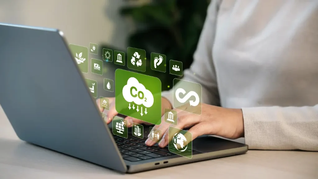 Mains tapant sur un clavier avec des icônes virtuelles liées à l’écologie et la réduction du CO₂.